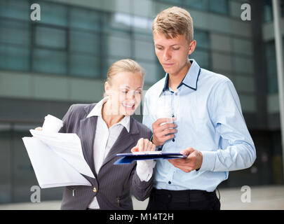 Avec sa femme d'employé sont la lecture de documents avant de signer à l'extérieur. Banque D'Images