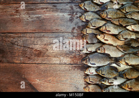 Poisson frais pêché la carpe sur le bois. Attraper les poissons d'eau douce sur fond de bois. Beaucoup de brèmes, le carassin poisson ou roach sur fond de bois naturel. Background Banque D'Images