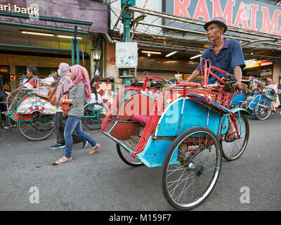 Pousse-pousse à vélo en voiture sur la rue Malioboro. Yogyakarta, Java, Indonésie. Banque D'Images