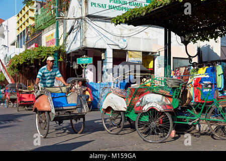 Pousse-pousse à vélo en voiture sur la rue Malioboro. Yogyakarta, Java, Indonésie. Banque D'Images