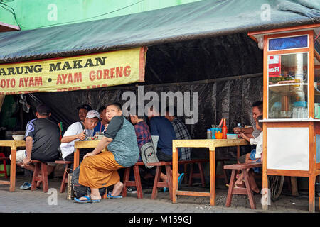 Les gens de manger dans un petit restaurant de rue sur Ketandan Wetan street. Yogyakarta, Java, Indonésie. Banque D'Images