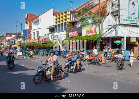 Les personnes en moto traversant la rue Malioboro. Yogyakarta, Java, Indonésie. Banque D'Images