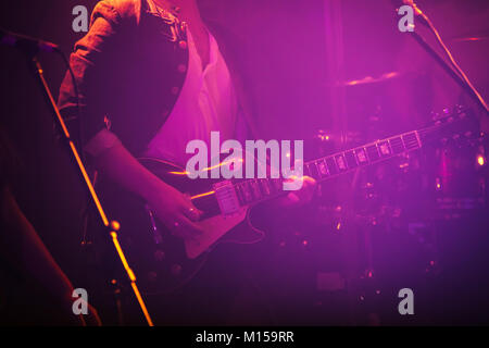 Joueur de guitare électrique en bleu et violet couleur de l'éclairage scénique, soft focus sélectif Banque D'Images