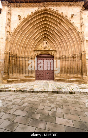 Porte de l'église espagnole massive avec surround finement sculptés et pavés en premier plan. Banque D'Images