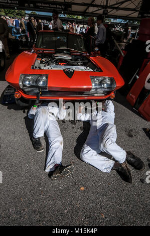 Mécaniciens travaillant sous une Chevrolet Corvette C2 Sting Ray dans le garage à Goodwood Revival 2016. Entretien, préparation de la course Banque D'Images