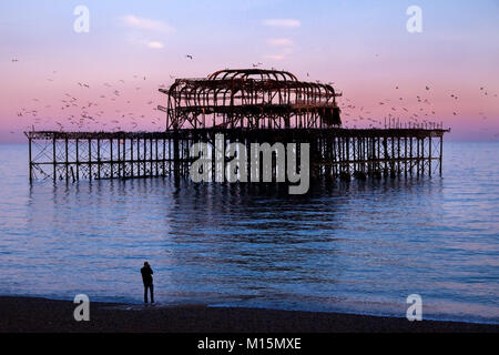 Brighton, Royaume-Uni, de l'épave jetée ouest, le cadre métallique travaux de la jetée Ouest abandonné au coucher du soleil, la mer est bleu et rose et reflétant le ciel Banque D'Images