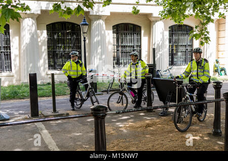 Londres, Royaume-Uni. Les officiers de police sur les bicyclettes en attente sur zone piétonne d'un quartier calme de la rue de Londres portant des casques et gilets haute visibilité Banque D'Images