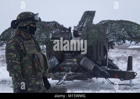 Un soldat roumain affecté à la base de la masse de l'Armée roumaine de défense aérienne, les chauves-souris noire, aide à mettre en place son équipe Oerlikon 35 mm double cannon à une gamme près de la zone d'entraînement Bemowo Piskie, Pologne, le 24 janvier 2018. La multinationale, unique, composé d'Américains, Britanniques, croate et soldats roumains servir avec la 15e Brigade mécanisée polonaise comme une force de dissuasion dans le nord-est de la Pologne à l'appui de l'OTAN vers l'amélioration de la présence. (U.S. Army Banque D'Images