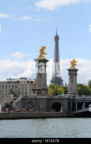 Vue de la tour Eiffel derrière les fames doré sculptures sur le socle des contrepoids à la périphérie de l'étang du pont Alexandre III, Seine River, Pari Banque D'Images