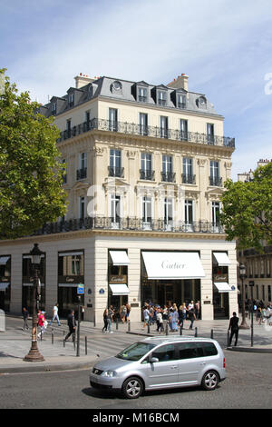 Une Volkswagen Touran argent roulant en face d'une boutique Cartier, l'Avenue des Champs-Elysées, Paris, France. Banque D'Images