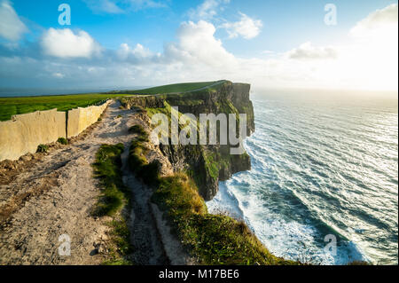Sentier du littoral à pied sur les falaises de Moher, les plus visités d'Irlande Attraction touristique naturelle, sont des falaises situées à la limite sud-ouest de la Banque D'Images