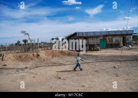 Petit garçon à pied dans le village Afrique Kenya Banque D'Images