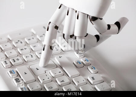 Close-up of main robotique appuyant sur la touche Entrée du clavier Banque D'Images