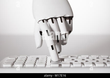 Close-up of main robotique appuyant sur la touche Entrée du clavier Banque D'Images