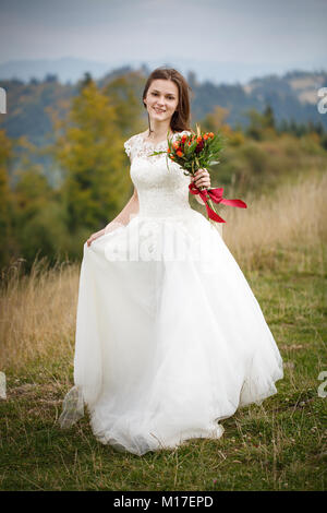 Beauté femme, mariée avec perfect white dress posing sur le rock fond montagne Banque D'Images