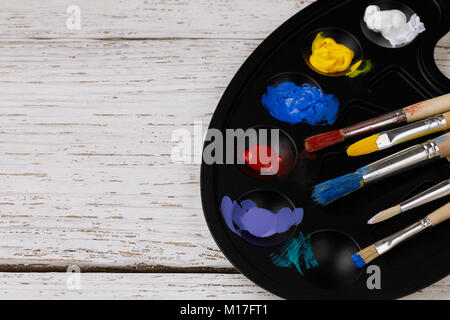 Palette avec les peintures et les glands pour dessiner sur une table en bois avec un espace réservé au texte Banque D'Images