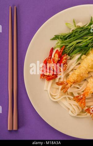 Crevettes Tempura de style japonais avec les nouilles Udon Piment et oignons de printemps contre fond violet Banque D'Images