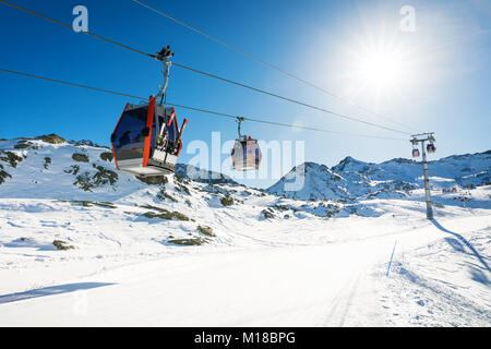 Gondoles remontées contre le ciel bleu sur pente à ski sur journée d'hiver ensoleillée à Italie Alpes Banque D'Images