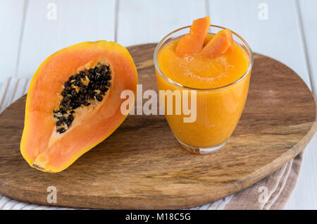 Smoothie papaye fraîche jus en verre sur fond de bois Banque D'Images