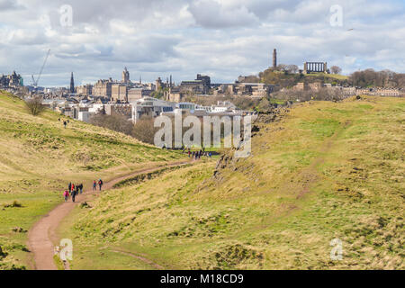 La ville d'Edimbourg à pied - walkers sur sentier menant de Holyrood Park jusqu'à Arthurs Seat et Salisbury crags, avec vue imprenable sur la ville Banque D'Images