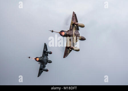 Couteau de l'armée de l'air delta display team paire de jet Mirage 2000 avions de combat. Tirant fort avec réchauffage de postcombustion et nuages de condensation Banque D'Images