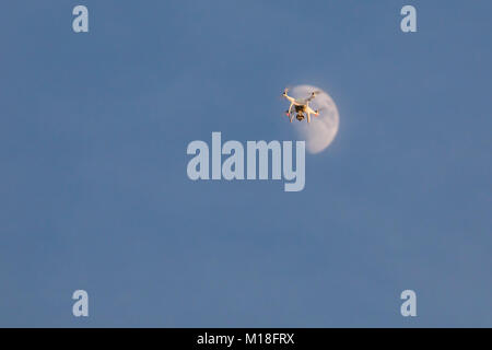 Bourdon blanc volant fantôme sur le ciel bleu. Un atterrissage droned part avec les hélices en rotation Banque D'Images