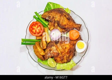 Frit épicé croustillant pomfret poisson avec frites et garni de légumes et les tranches d'oeufs. Une populaire Bengali cuisine indienne. Banque D'Images