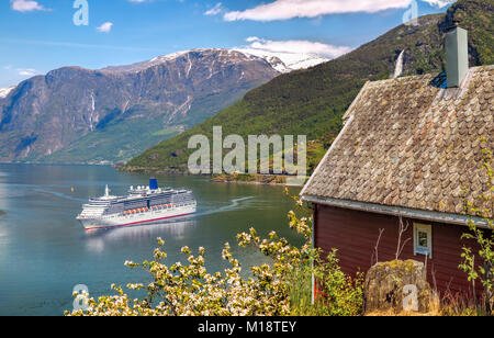 Chalet rouge contre le navire de croisière en fjord, Flam, Norvège Banque D'Images