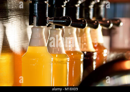Les poignées de bière La bière verser dans des bouteilles. Banque D'Images