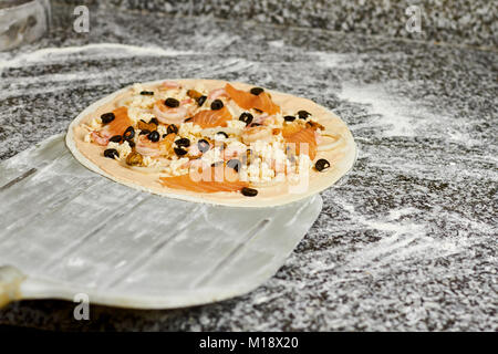 Pizza pizza métal peel en tenant de la table. Banque D'Images