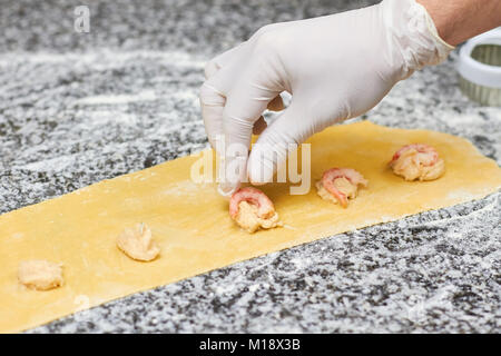 Rangée de mettre les crevettes sur la pâte. Banque D'Images