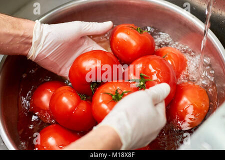 Laver les tomates dans de l'eau Chef, Close up. Banque D'Images