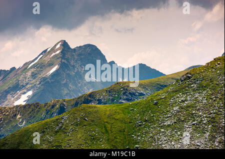 Derrière le tor rocheux pente gazonnée. beau paysage dans les montagnes sur un jour nuageux Banque D'Images