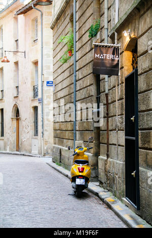 Scooter jaune en stationnement sur rue du Puits Descujols, Bordeaux, Gironde, Nouvelle-Aquitaine, France. Banque D'Images