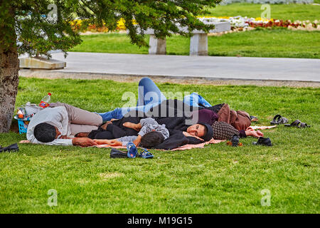 Isfahan, Iran - le 24 avril 2017 : famille iranienne est en train de dormir allongé sur la pelouse dans le parc de la ville. Banque D'Images