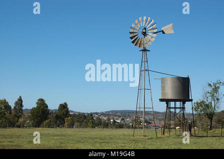 Moulin à vent et tankstand au paddock, Queensland, Australie. Les moulins à vent sont couramment utilisées pour pomper de l'eau à partir de barrages ou les alésages d'auges pour le bétail. Banque D'Images