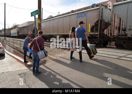 Les piétons attendre qu'un train de marchandises de l'Union Pacific transportant des marchandises en provenance du Mexique passe de Nogales, Sonora, Mexique, à Nogales, Arizona, USA, au Banque D'Images