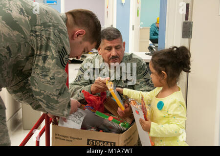 Thomas SrA Waldorf, à gauche, et le conseiller-maître Sgt. Rosales, recherchez la petite fille parfaite que les jouets qu'ils offrent des jouets pour tous les âges à la Loma Linda University Children's Hospital, le 14 décembre 2012. Les aviateurs du California Air National Guard espéraient de visiter et d'égayer la journée des enfants avec les cadeaux que les enfants reçoivent des soins au patient hors centre où ils ont souvent de visiter plusieurs fois par semaine.(Air National Guard photo/Master Sgt. Julie Avey) Banque D'Images