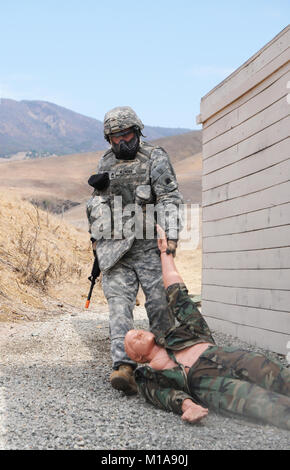 130911-Z-IB797- SPC. Roman Orlov, La Compagnie Bravo, 223e renseignement militaire, fait glisser une victime simulée à partir de la maison de tir sur la voie des opérations en zone urbaine, le 11 septembre 2013, lors de la Californie de l'Army National Guard meilleur guerrier de la concurrence, qui a eu lieu au Camp San Luis Obispo, Californie, par l'Institut régional de formation 223e. (U.S. Photo de la Garde nationale par la CPS. James Wilton/libérés) Banque D'Images