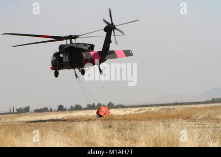 La Garde Nationale de Californie UN UH-60 Black Hawk quitte l'Aéroport Municipal de Coalinga le 13 juillet à la bataille de Garza incendie dans le comté de Kings, en Californie. Cinq Black Hawks de CalGuard ont répondu à l'incendie, l'un de Garza près de deux douzaines de feux de flambage le Golden State à la mi-juillet 2017. Il avait déjà consommé plus de 26 000 acres et a été de 30 pour cent par la Californie, ministère des Forêts et de protection contre l'incendie (CAL). (Photo/Garde nationale d'armée le s.. Eddie Sigüenza) Banque D'Images