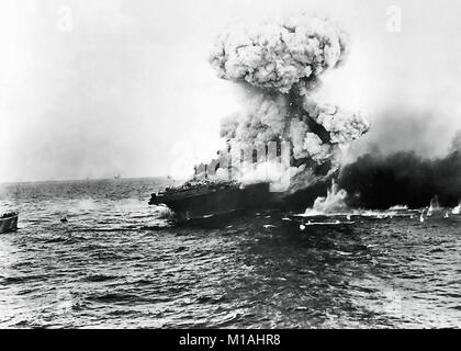 Bataille de la mer de Corail, mai 1942. Un "nuage champignon' augmente après une forte explosion à bord du USS Lexington (CV-2), 8 mai 1942. C'est probablement la "grande explosion" de la détonation d'ogives torpille rangés dans le côté tribord du hangar, à l'arrière, qui a suivi une explosion au milieu du bateau à 1727 heures. Remarque USS Yorktown (CV-5) à l'horizon dans le centre gauche, et le destroyer USS Hammann (DD-412) à l'extrême gauche. Banque D'Images