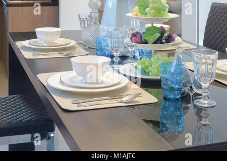 Chinaware réglage sur table à manger avec du verre de cristal bleu et de fruits Banque D'Images