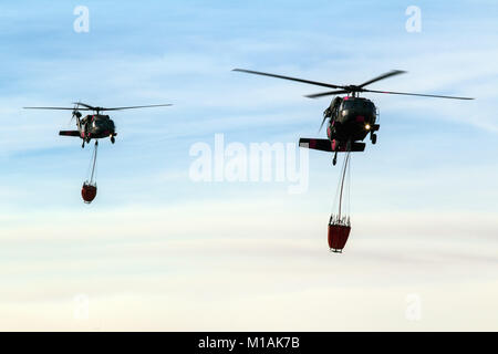 Une paire de Californie National Guard hélicoptères UH-60 Black Hawk de la Compagnie B, 1er Bataillon, 140e Régiment d'aviation, de la terre pour faire le plein à l'aéroport de Camarillo de Camarillo, Californie, le samedi, Décembre 9, 2017. Les hélicoptères ont passé la journée à l'abandon de l'eau sur le feu Thomas, en coordination avec le feu. Par Thomas samedi soir, le feu a brûlé 173 000 hectares et détruit plus de 500 structures depuis qu'il a commencé le 4 décembre. (U.S. Photo de la Garde nationale aérienne Aviateur Senior Housman Crystal) Banque D'Images