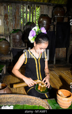 Jolie jeune femme, qui sert des boissons à l'aide d'artéfacts de bambou mari Mari Cultural Village, Kota Kinabalu, Sabah, Bornéo, Malaisie Banque D'Images