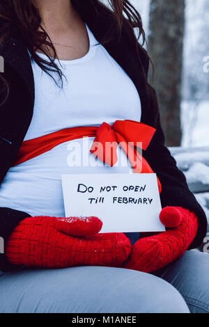 Cesis, ville de l'hiver, décembre, la Lettonie, la femme enceinte attendre brûler girl, la nature et la neige. Gants rouge. 2016 Banque D'Images