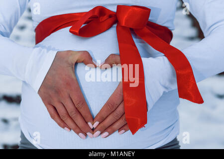 Cesis, ville de l'hiver, décembre, la Lettonie, la femme enceinte attendre brûler girl, la nature et la neige. Gants rouge. 2016 Banque D'Images