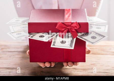 Close-up of a Woman Holding Gift Box de US Dollar Bills Banque D'Images