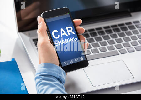 Close-up of a Woman en utilisant le Service de partage de voiture sur Smart Phone Banque D'Images