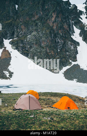 Les tentes de camping en haute montagne sur fond de pics rocheux et un lac gelé. Le concept d'un mode de vie en plein air sports d'aventure. L Banque D'Images