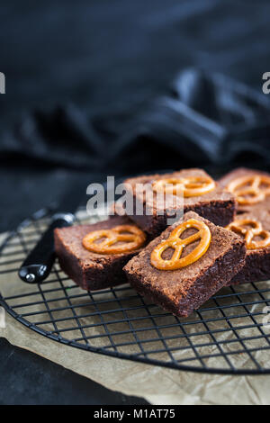 Brownies au chocolat maison avec Bretzels salés sur le dessus, Close up, fond sombre Banque D'Images